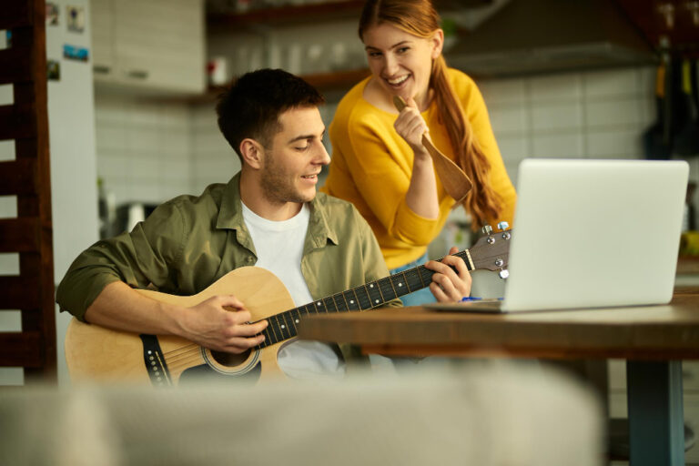 koppel-leert-online-gitaar-spelen-in-keuken.jpg